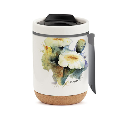 A white travel mug with a cork base, a black lid, and a watercolor image of a flowering saguaro cactus, displayed with a product tag attached.