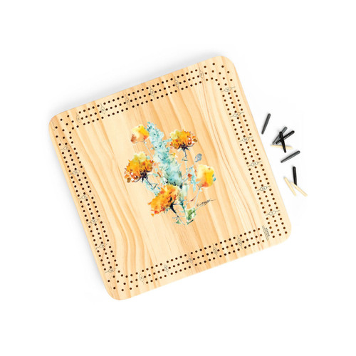 A light wood cribbage board game with the watercolor image of a sagebrush in the middle, displayed angled to the right with the playing pieces off and to the right.