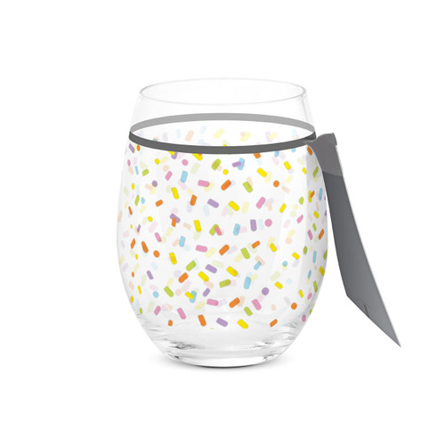 A clear stemless wine glass with a bright colorful confetti pattern all around the glass, displayed with the product tag attached.