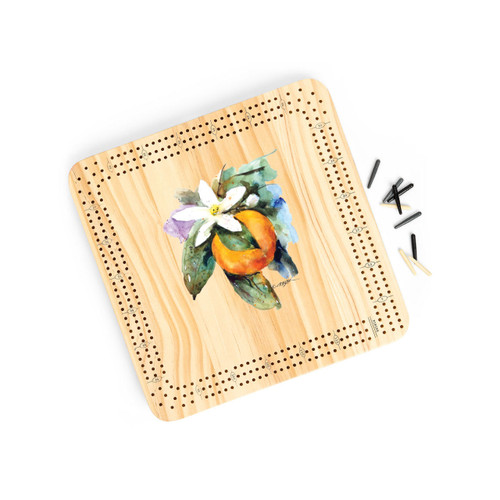 A light wood cribbage board game with the watercolor image of an orange blossom in the middle, displayed angled to the right with the playing pieces off and to the right.