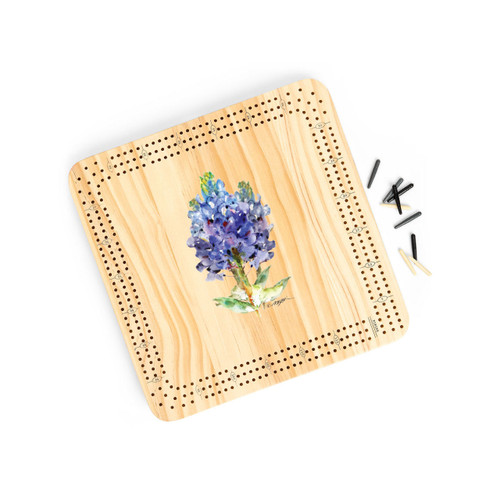 A light wood cribbage board game with the watercolor image of a bluebonnet in the middle, displayed angled to the right with the playing pieces off and to the right.