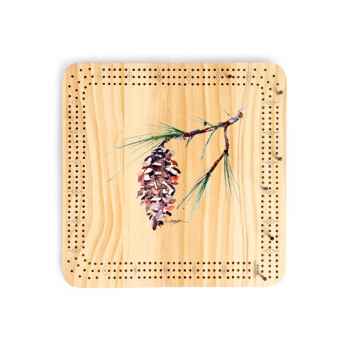 A light wood cribbage board game with the watercolor image of a white pine branch in the middle.