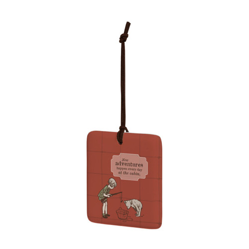 A square red hanging tile magnet ornament that says "New adventures happen every day at the cabin" with an image of Christopher Robin and Pooh fishing in a tub, displayed angled to the left.