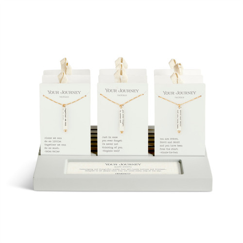 A gray tabletop slotted displayer with an assortment of different quote necklaces in packaging.