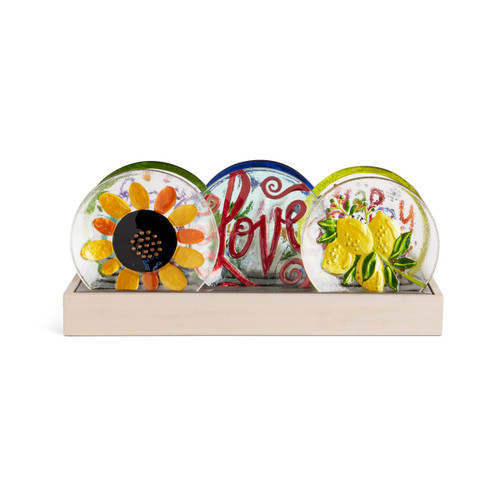 A light wood slot displayer box with an assortment of mini glass plates in a spring theme.