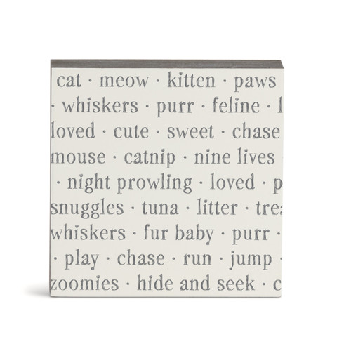 A white square wall art with words about cats on it.