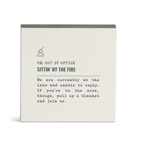 A white square wall art with the saying "RE: Out of Office Sittin' by the Fire" with a short write up about someone sitting by a fire at the lake.