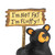 Detail view of the sign on a sitting black bear figurine holding a sign that says "I'm Not Fat I'm Fluffy!".