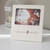 A cream ceramic 4x6 photo frame that says "heaven sent" in cursive at the base, displayed on a white countertop.