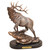 A carved sculpture by Marc Pierce of an elk herd bull walking up a grassy slope with its head up. The sculpture is on a dark brown base and has a gold plate that says "Herd Bull".