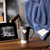 A living room display of Dad themed items such as a blue blanket, a gray travel mug and a black ceramic photo frame.
