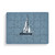 A rectangular wood 24 piece postcard puzzle with a white sailboat on a blue background.