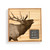 A square wood board for tic tac toe with an image of an elk, shown in a packaging box with a product information tag.