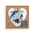 A heart shaped wood peg game with a watercolor painting of a luna moth, displayed in a packaging box with a product information tag.