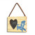 A pale yellow rectangular hanging wood frame with a 2 inch heart shaped opening for a photo next to an image of a blue Adirondack chair angled to the left.