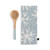 A light blue kitchen towel with white snowflakes next to a wood spoon with a light blue handle.