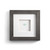 A square gray wood framed image of a single light green heart shaped pebble.