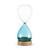 A glass sand timer with blue glass on the bottom half sitting in a wood base that says "a little me time".