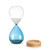 A glass sand timer with blue glass on the bottom half sitting in a wood base that reads "a little me time", displayed with the timer outside the base.