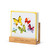 A square oil diffuser with a watercolor image of colorful butterflies on it set in a wood stand that says "relax, renew, refresh", displayed angled to the left.