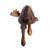Back view of a carved figurine of a dark brown moose with tan antlers and a small blue bird perched on them, that sits on a shelf with a front leg hanging down.