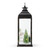 Right profile view of a lit black metal lantern with a winter village scene inside with snow and evergreens.