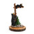 A figurine of an adult black bear standing at the base of a tree with a small bear up on a branch.