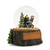 A glass snow globe with a sitting black bear next to a pine tree. The base is sculpted like a tree trunk and has a rectangular space for personalization, displayed angled to the right.