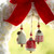 Three different red and white mini bells hung inside a white large knit wreath with a red bow hanging on a window.