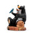 Left profile view of a figurine of a black bear sitting on a log with his forest friends including a fox, racoon and bird. The base says "Friends".