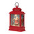 A red lit musical lantern with the image of Santa standing by his sleigh in the snow, displayed angled to the left.