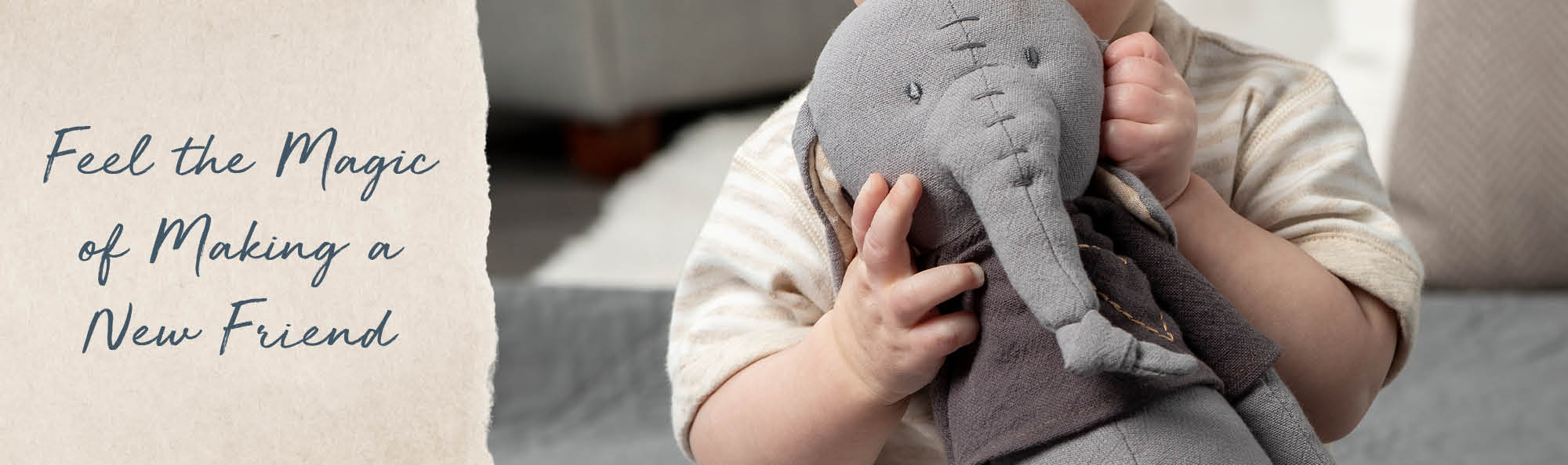 Feel the magic of creating a new friend. Baby holding a stuffed elephant with hand-stitched details.