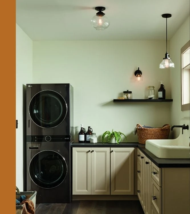 A coordinated lighting set in a laundry room, including a glass globe semi-flush mount ceiling light, a matching glass pendant light, and a small wall sconce.