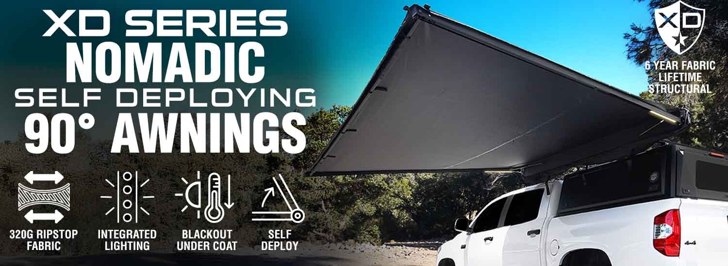 OVS XD Nomadic 90 degree self-deploying awning with blackout undercoat and integrated LED lighting deployed on vehicle