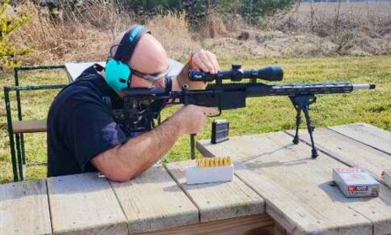 man adjusting the optic sight on a rifle