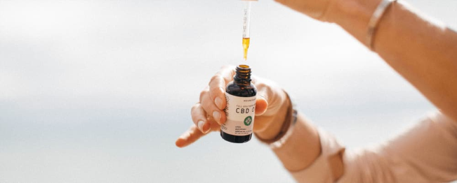 title Girl holding CBD Oil Dropper