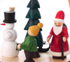 Features three hand carved Christmas time figures on the lower turntable: 1 Santa pulling a sled full of presents, 1 Snowman with classic carrot nose and broom stick, and 1 figure leading the way with a handcrafted lantern; hand-painted rotating tree in center