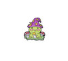 Magic Witch Frog enamel pin sitting on green grass with bright red mushrooms on either side holding a want. HP-36
