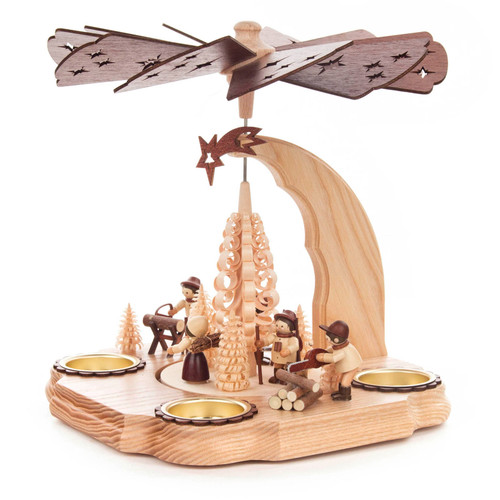 Authentic German Pyramids ON SALE! | Features five handcarved forest workers: 1 sawing logs, 2 carrying kinlin, 1 sawing logs with a chainsaw, and 1 petting a dog; intricate trees made from shavings throughout with curved design outlining 4 brass candle holders. USE: Place the candle in the designated holders on the pyramid. Heat from the candle will slowly cause the blades to rotate. | 1-Tier Waldarbeiter (Forest Workers), 9" 085/P/999/D/2 | Handmade in the Erzgebirge region of Seiffen, Germany | Lindenhaus Imports in Helen, Ga