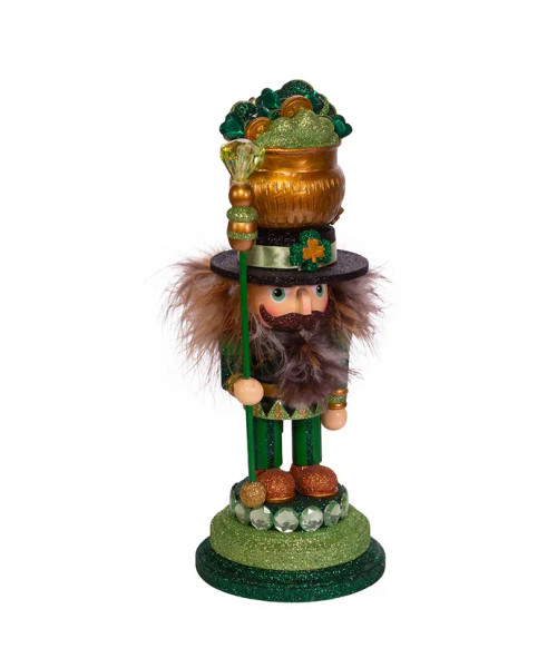 Partial front/side view features green and gold glitter on an emerald base. In his right hand he's holding an emerald gem topped staff. His hat is his lucky pot o' gold complete with glittered shamrocks and gold pieces. Partial front/side view features green and gold glitter on an emerald base. In his right hand he's holding an emerald gem topped staff. His hat is his lucky pot o' gold complete with glittered shamrocks and gold pieces.