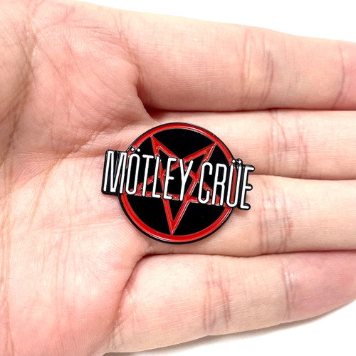 Mötley Crüe Pin lying in palm of hand. Mötley Crüe Pin lying in palm of hand.