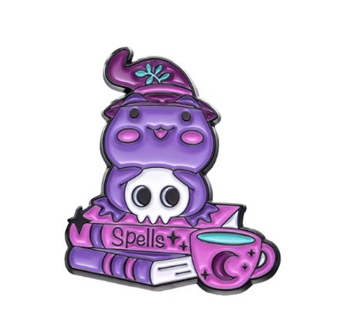 Purple Frog Witch perched on a stack of 'SPELLS' books holding a skull HP33 Purple Frog Witch perched on a stack of 'SPELLS' books holding a skull HP33