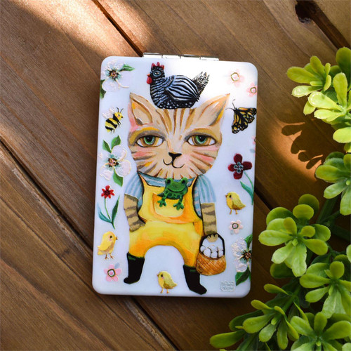 Farm Cat Compact Mirro on decorative wood background with green plants Farm Cat Compact Mirro on decorative wood background with green plants