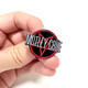 Mötley Crüe Pin being held with fingers.