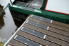 Heskins Bolt Down Anti-Slip Plates installed on a canal boat and dock deck — heavy-duty rectangular plates providing mechanically-fastened slip protection (shown with standard grit; photoluminescent glow surface available)