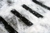 Heskins Bolt Down Anti-Slip Plates providing traction on outdoor steps in snowy winter conditions — pre-drilled aluminum plates rated for freeze-thaw exposure from -22°F to +158°F