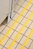 SafetyMark Coarse Resilient anti-slip tape - yellow safety stripes applied to a tiled floor near equipment