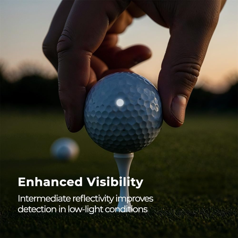 Golfer holding a golf ball with a LiteMark reflective dot applied at dusk, demonstrating Enhanced Visibility — intermediate reflectivity improves detection in low-light conditions