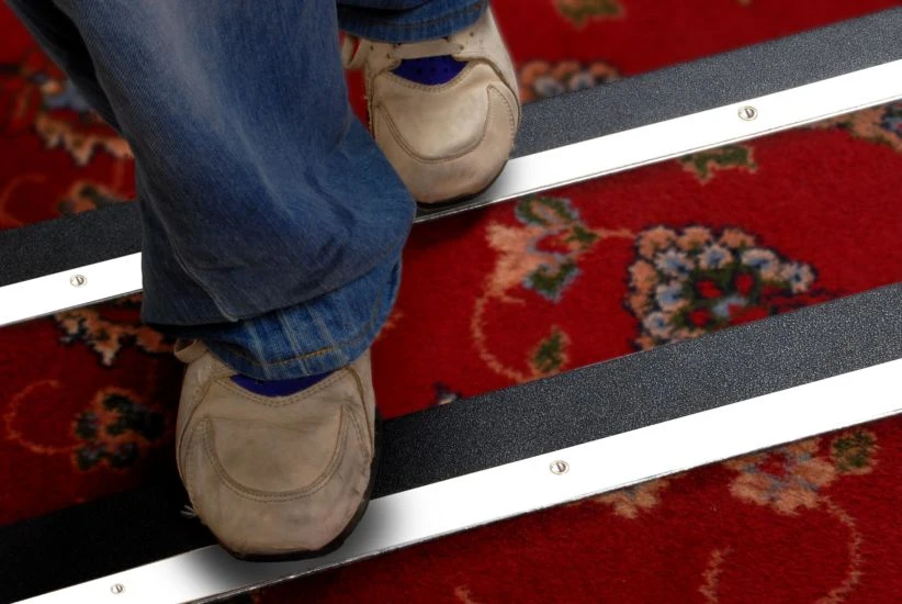 SafetyMark Coarse Resilient anti-slip tape - black stair treads applied to a carpeted staircase