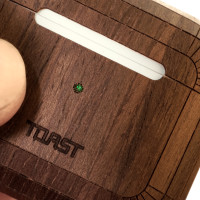 Toast AirPods 3 case cover in walnut, detail of lasercut indicator light.